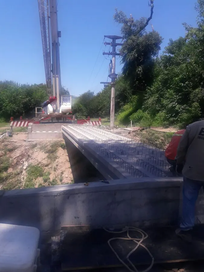 Montaje de vigas en puente — Colocación en obra, con grúa, de vigas pretensadas sobre los estribos del puente.